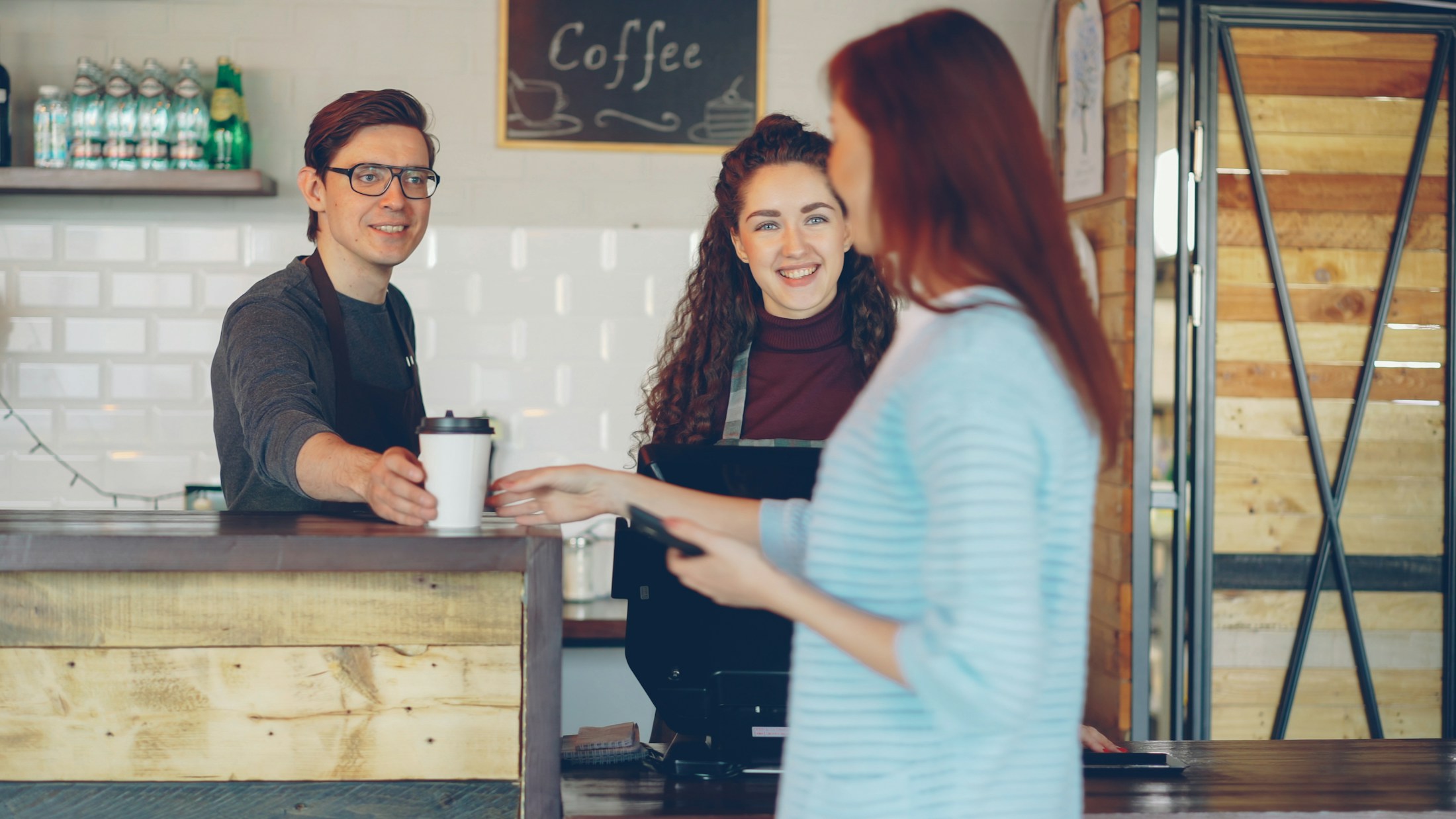 A customer and café team sharing a moment at the counter.